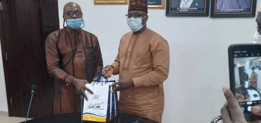 Mr. Shonde G.O presents a souvenir to Mr. Kamal Olowoshago, Perm. Sec. Transportation, on behalf of PMG NIPOST after a meeting.